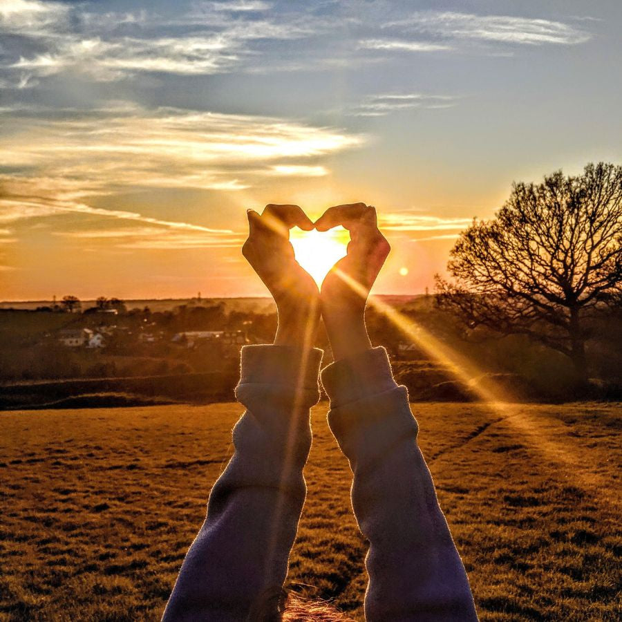 heart hands over the sunset