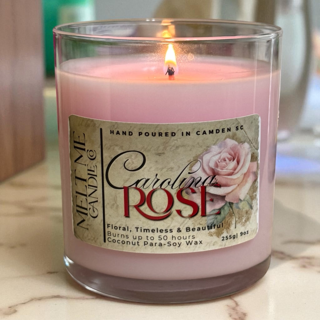 Pink candle labeled 'Carolina Rose' with a rose design on a marble surface.