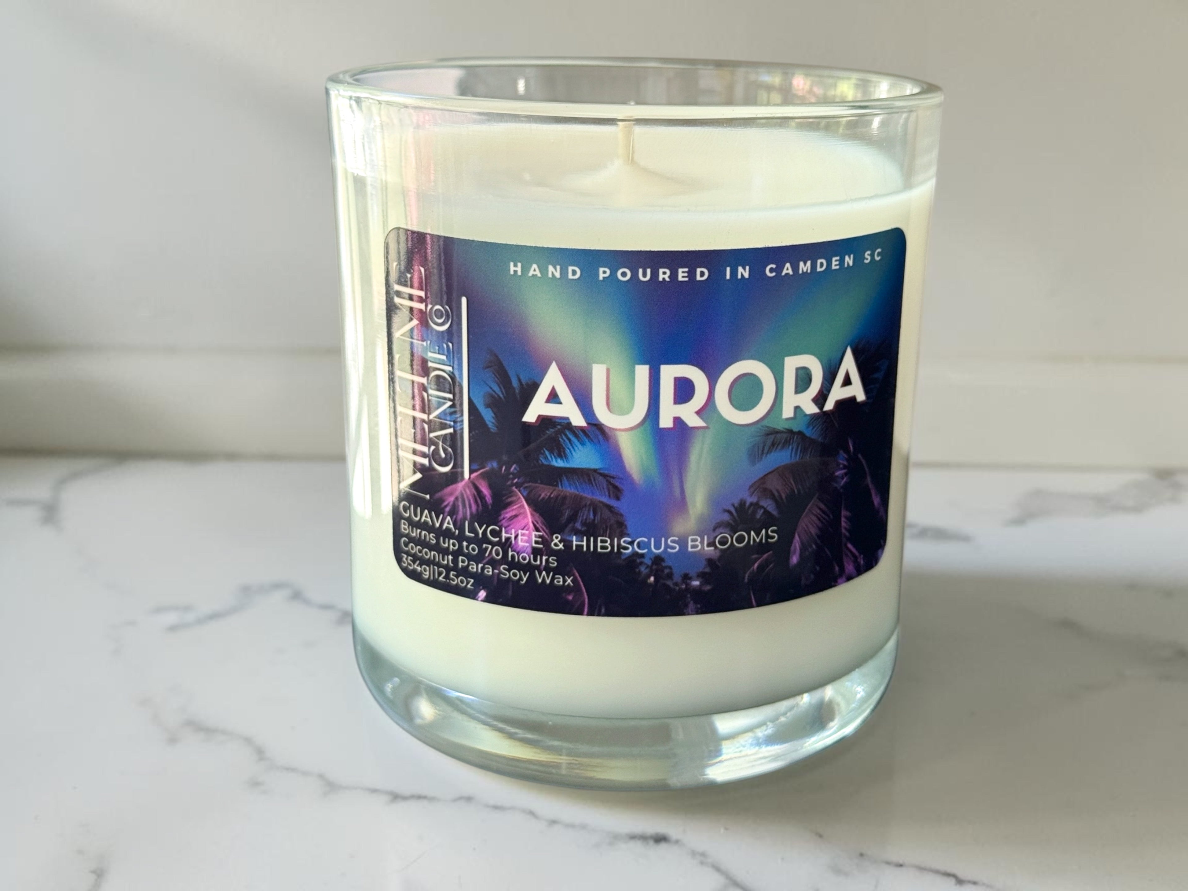 Candle with 'Aurora' label on a marble surface