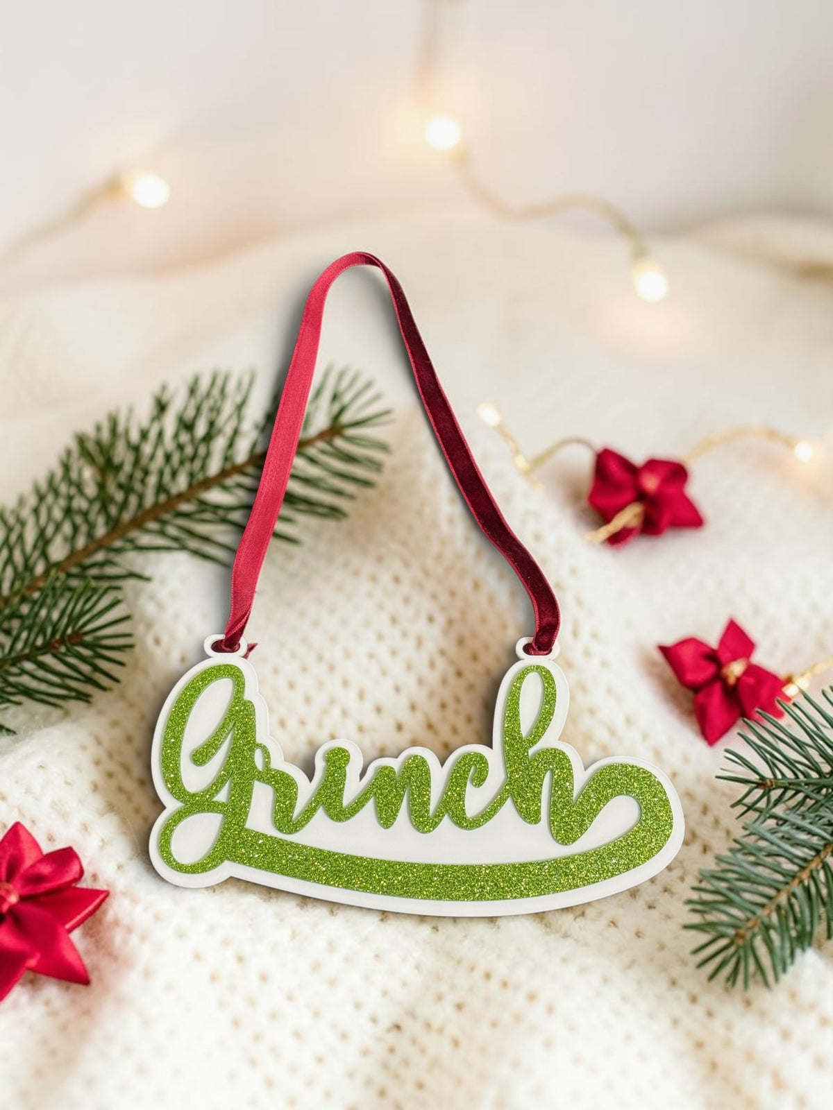 Grinch hanging sign made from shiny white and sparkling green acrylic with red velvet textured ribbon