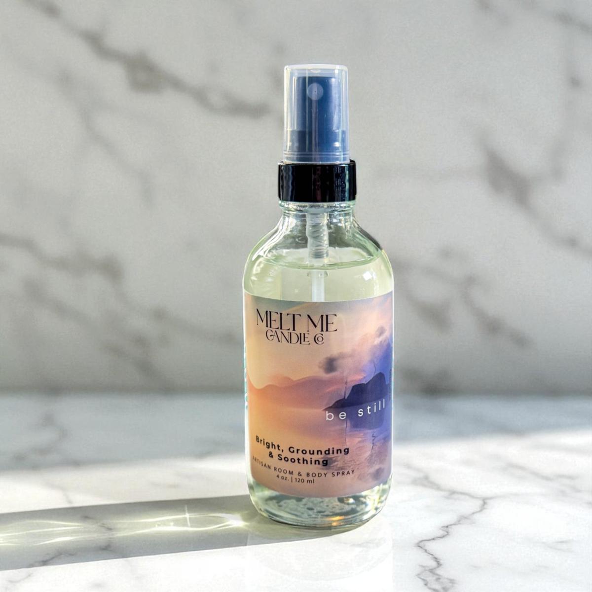 Bottle of 'Be Still' body spray on a marble surface