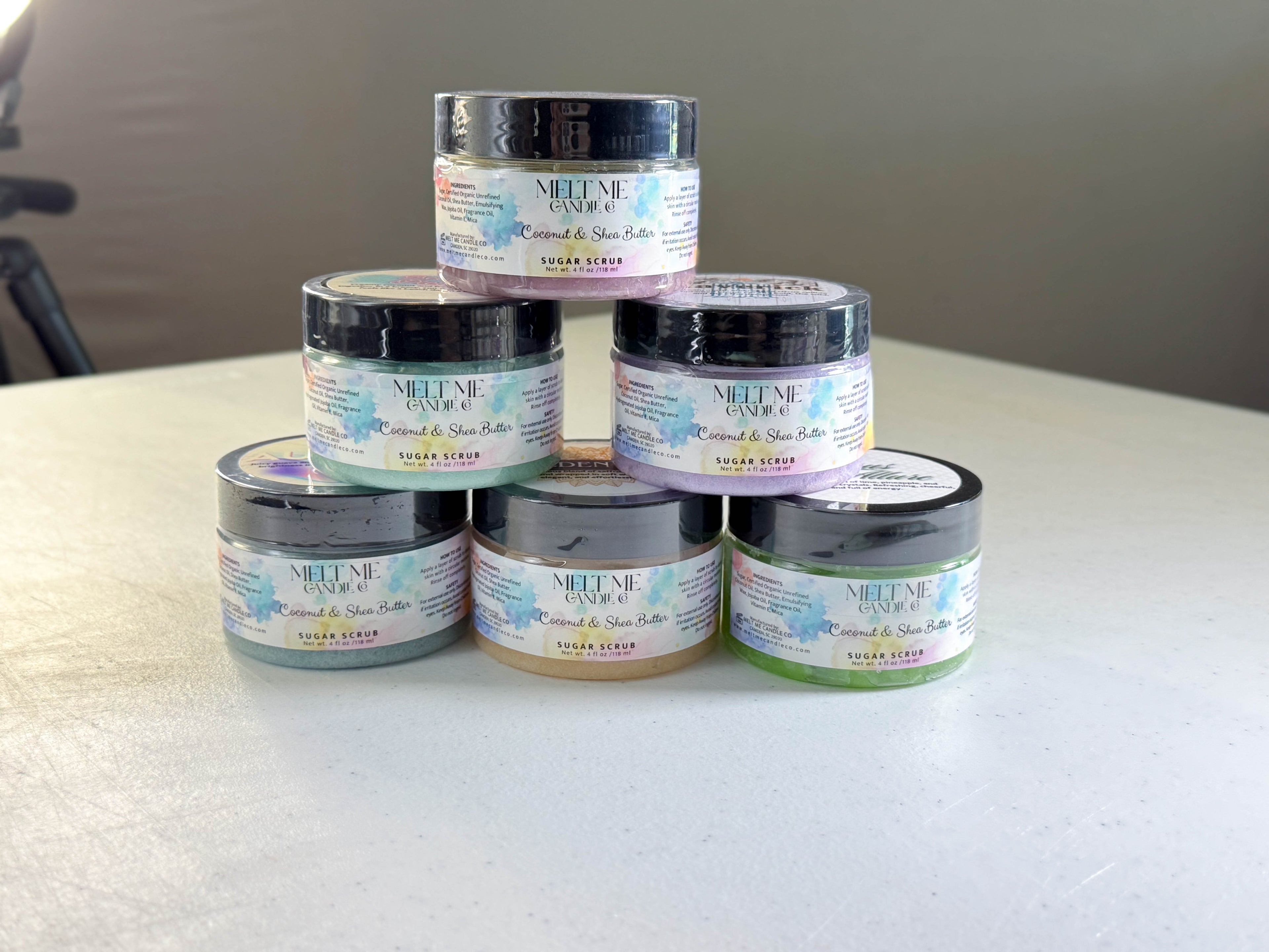 Stack of body scrub containers with scent options