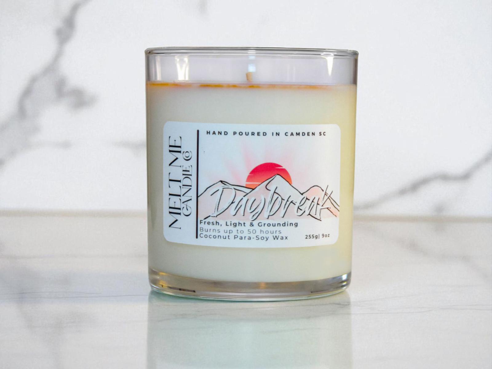 Candle with a 'Daybreak' label on a marble surface