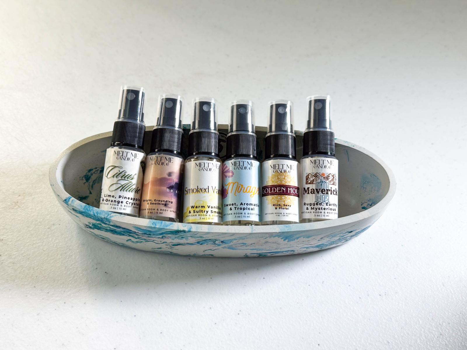 Set of small spray bottles in a decorative bowl on a light background