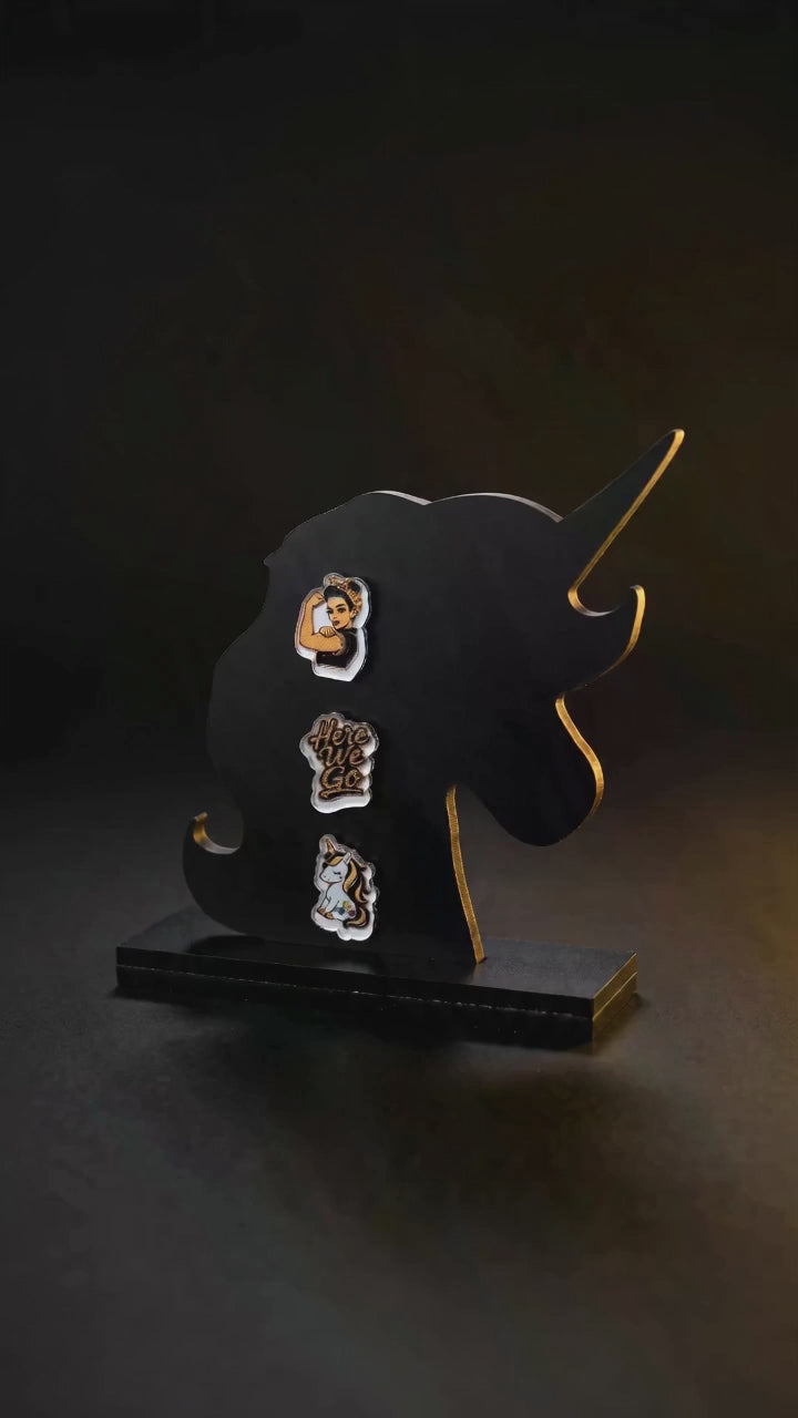 video of black unicorn earring holding that is holding three earrings
