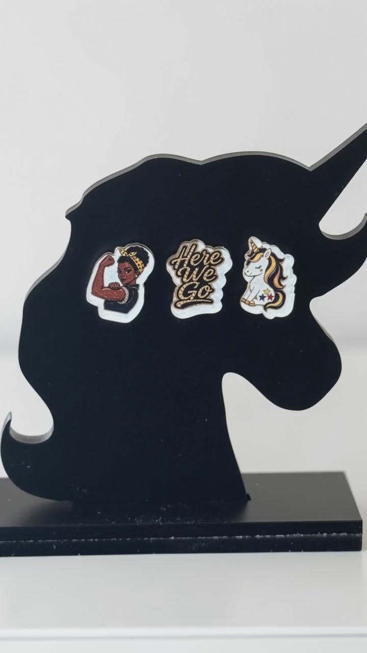 stud earrings on a black unicorn earring holding showing side to side video